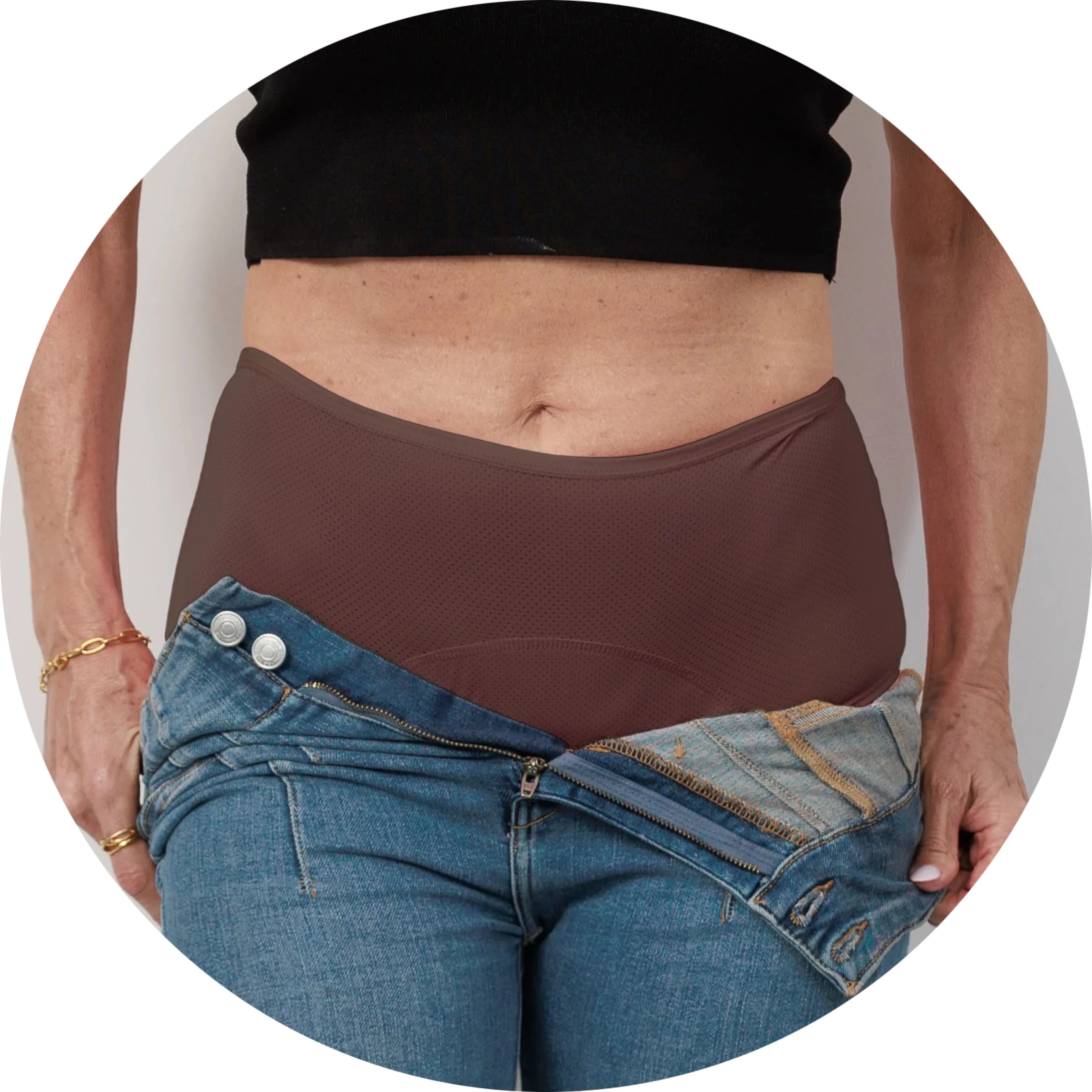 Person wearing brown high-waisted underwear and unbuttoned jeans.